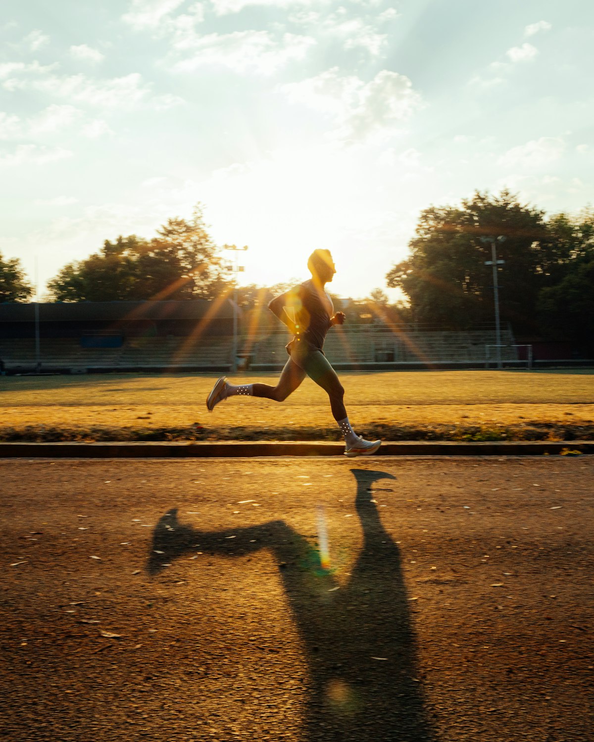Runner sprinting on a track in golden sunlight